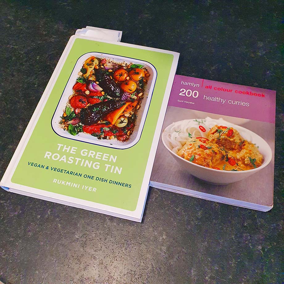 The Green Roasting Tin and 200 Healthy Curries books on a grey kitchen countertop